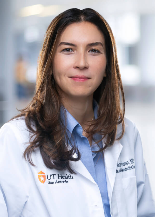 Oriana Haran-Anschel, MD, in her white coat.