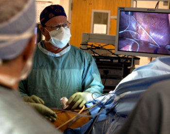 A surgeon looking into a monitor during a laproscopy