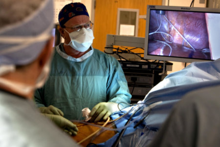 A surgeon looking into a monitor during a laproscopy