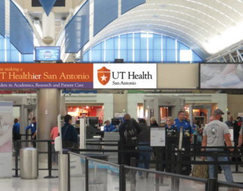UT Healthier campaign sign at the San Antonio International Airport.