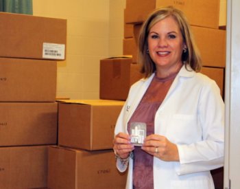 Lisa Cleveland, Ph.D., RN, and boxes of Narcan, which can reverse an opioid overdose.