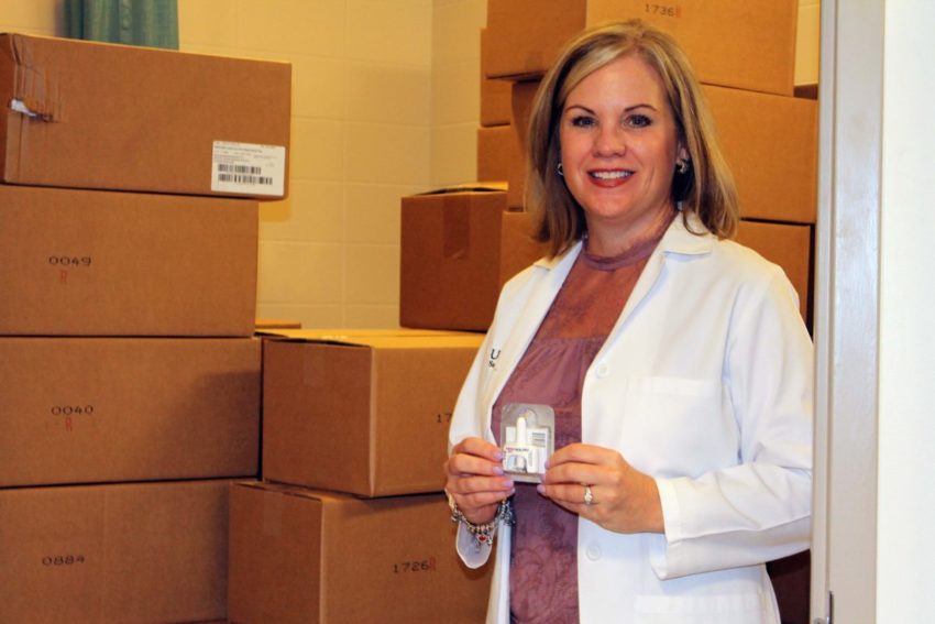 Lisa Cleveland, Ph.D., RN, and boxes of Narcan, which can reverse an opioid overdose.