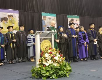 President William L. Henrich, M.D., MACP, stands at a podium at the School of Health Professions and School of Nursing joint commencement ceremony