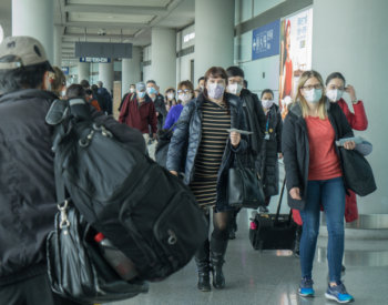 travelers wear face masks in airport.