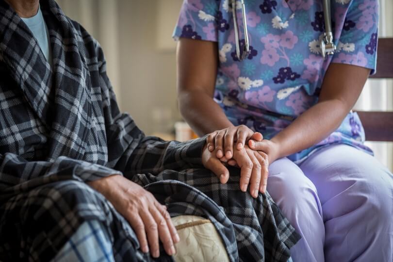 Picture of Caregiver holding hand of patient