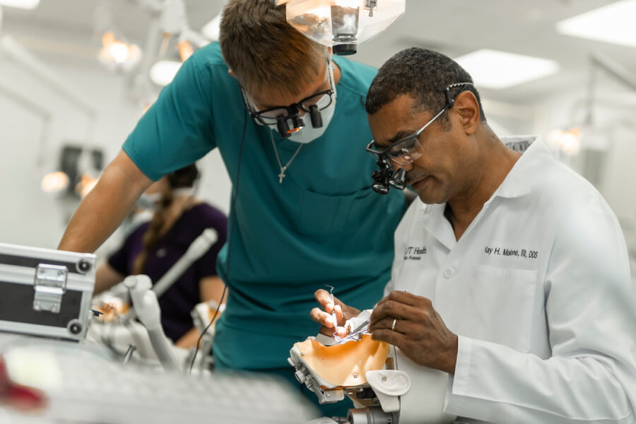 Dental faculty member demonstrates proper technique to a dental student.