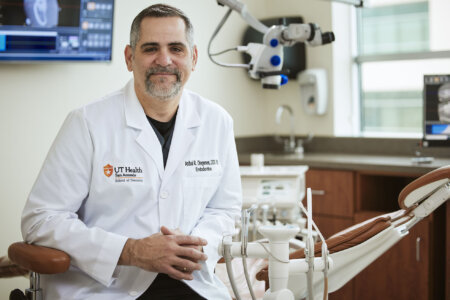 Dr. Diogenes in his white coat sitting in the clinic.