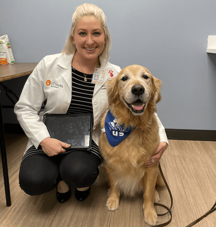 Dr. Meredith Stensland hugs Gus, a golden-retriever therapy dog.
