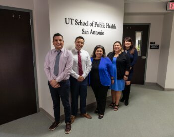 Delegates from U.S. Congressman Joaquin Castro's office line up in front of the School of Public Health's sign.