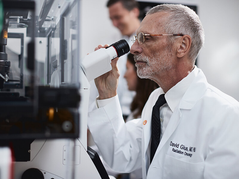 David Guis, MD, PhD, looks through a microscope.