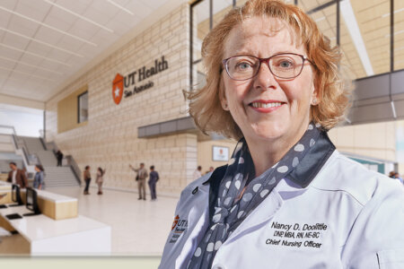 Nancy Doolittle, DNP, RN, in front of rendering of the UT Health San Antonio Multispecialty and Research Hospital.