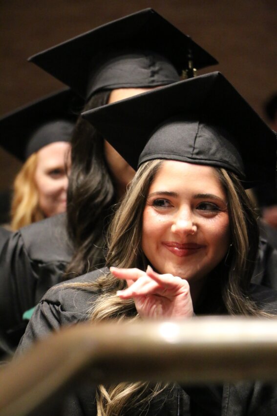 Master of Physician Assistant Studies graduate waves during commencement ceremony.