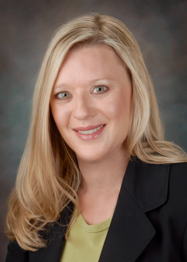 Professional headshot of Dr. Gonzales in a dark blazer.
