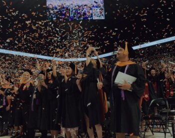 Smiling students from Class of 2025 celebrating graduation with confetti.