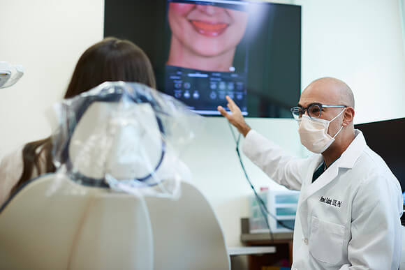 Dr. Sabbah points to a large monitor of a patient's digital image.