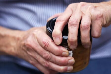 A close up photo of hands opening a jar.