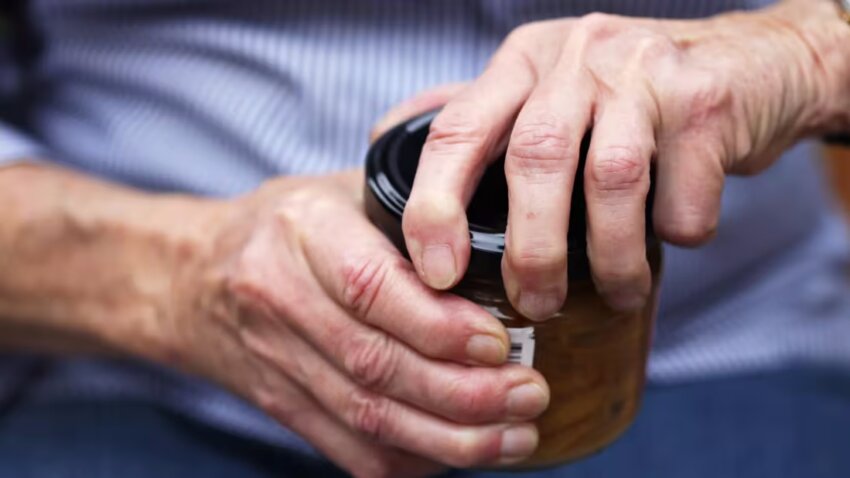 A close up photo of hands opening a jar.