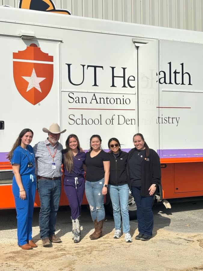 Students pose with Dr. Stafford in front of the mobile clinic.