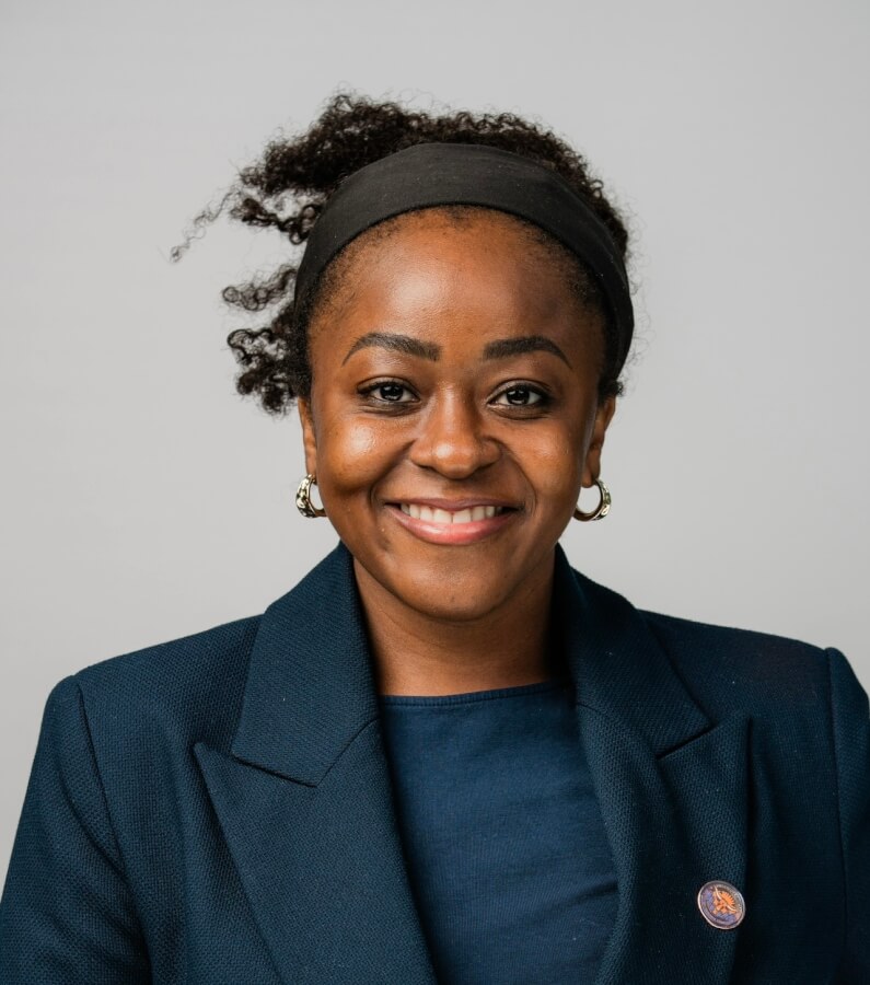 Dr. Opoku-Ansah in a navy blazer.