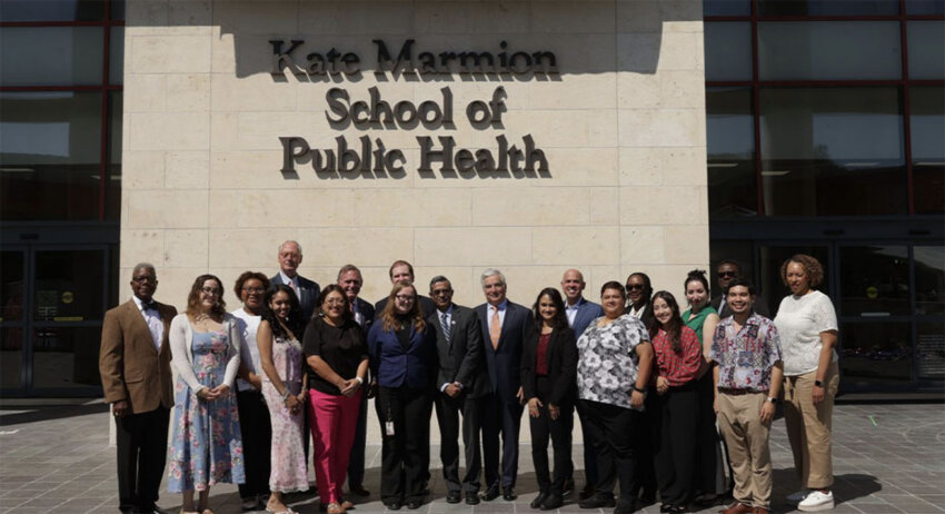 faculty and students stand in front of the Kate Marmion School of Public Health name.