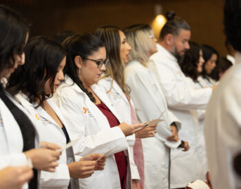 Students from the Medical Laboratory Sciences Class of 2027 take an oath pledging to provide the highest standard of ethical care to patients during their White Coat Ceremony at the Holly Auditorium.