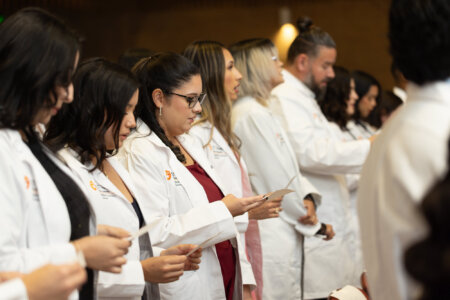 Students from the Medical Laboratory Sciences Class of 2027 take an oath pledging to provide the highest standard of ethical care to patients during their White Coat Ceremony at the Holly Auditorium.