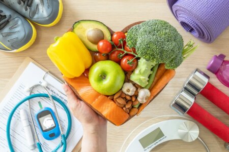 Conceptual image depicting Healthy lifestyle on ketogenic diet, eating clean keto food good health dietary in heart dish with aerobic body exercise, gym workout training class , weight scale and sports shoes in fitness center.