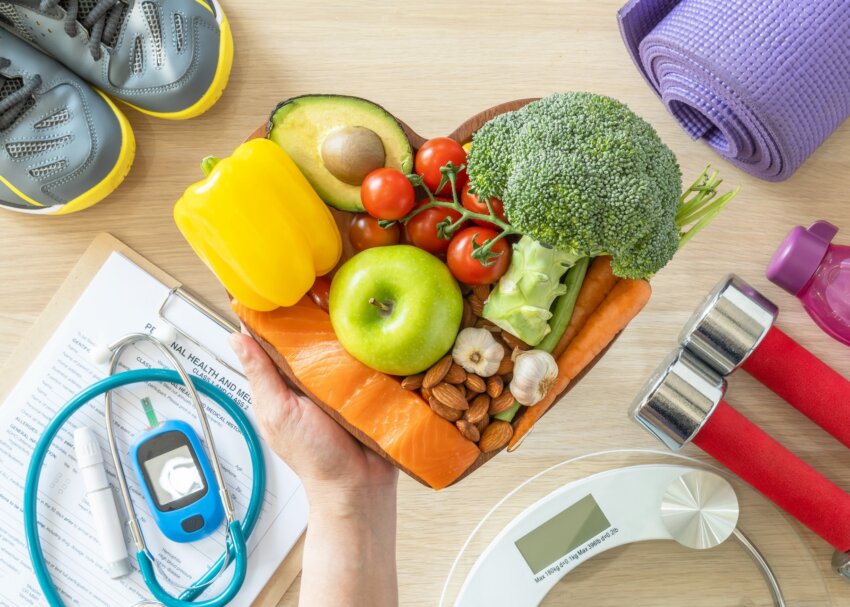 Conceptual image depicting Healthy lifestyle on ketogenic diet, eating clean keto food good health dietary in heart dish with aerobic body exercise, gym workout training class , weight scale and sports shoes in fitness center.