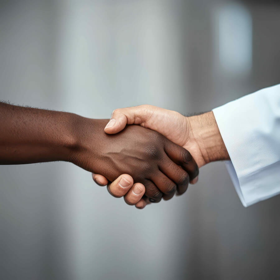 Stock image close-up photo of a doctor and patient shaking hands.