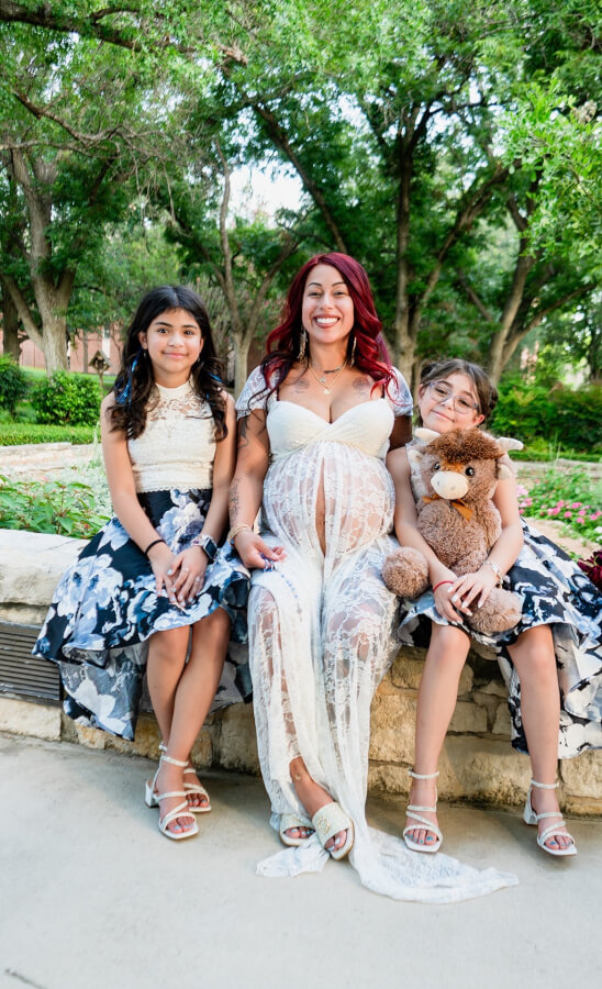 Deziree Ibarra and her two nieces sit together during a professional maternity shoot.