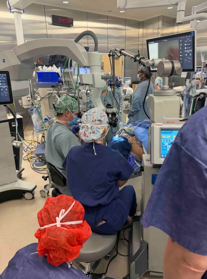 An multidisciplinary team surround Alison Sendejo as Dr. Jake Morgan operates to open her airway.