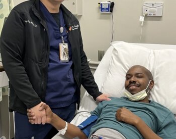 Tony Hsu, left, supervisor of apheresis and cellular therapy services at UT Health San Antonio’s Mays Cancer Center and UT San Antonio Multispecialty and Research Hospital, stands next to multiple myeloma patient Joseph Hall during the apheresis process in which blood -forming stem cells are collected, while the remaining blood is returned to the patient. Later, after the patient completes chemotherapy, the stored cells are infused back into the bloodstream. The cells travel to the bone marrow and begin producing new blood cells, helping blood counts recover over time